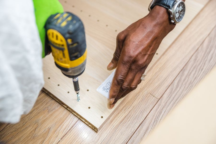 電動ドライバーで家具を組み立てる手元